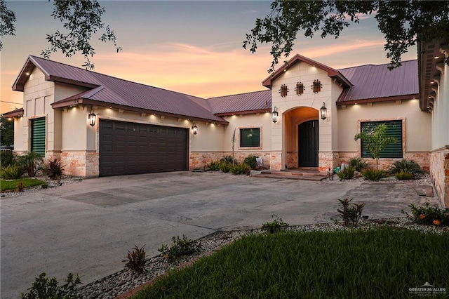 1320 S Cesar Chavez Rd, Edinburg, TX 78542 - view of front of home featuring stone siding, a metal roof, concrete driveway, and an attached garage