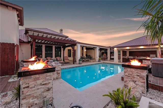 1320 S Cesar Chavez Rd, Edinburg, TX 78542 - pool at dusk featuring a fire pit, an outdoor pool, and a patio
