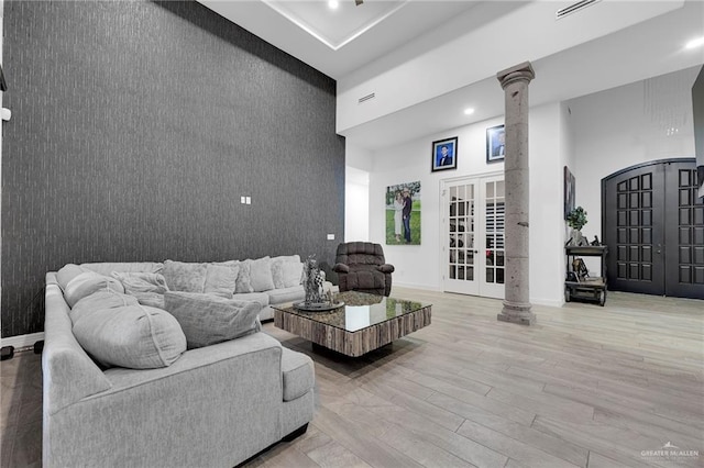 1320 S Cesar Chavez Rd, Edinburg, TX 78542 - living area with ornate columns, a towering ceiling, an accent wall, french doors, and wood finished floors
