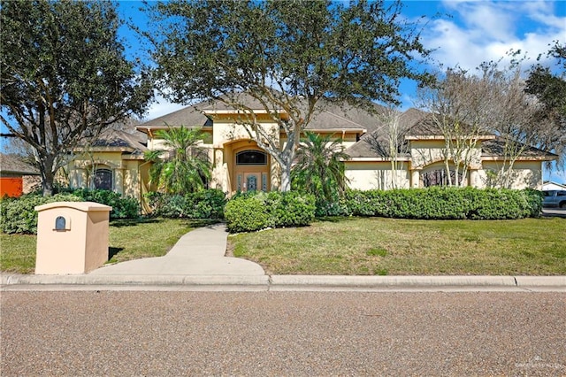 mediterranean / spanish-style home featuring stucco siding and a front yard