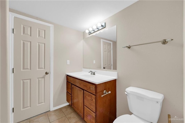 half bath with toilet, vanity, and tile patterned floors