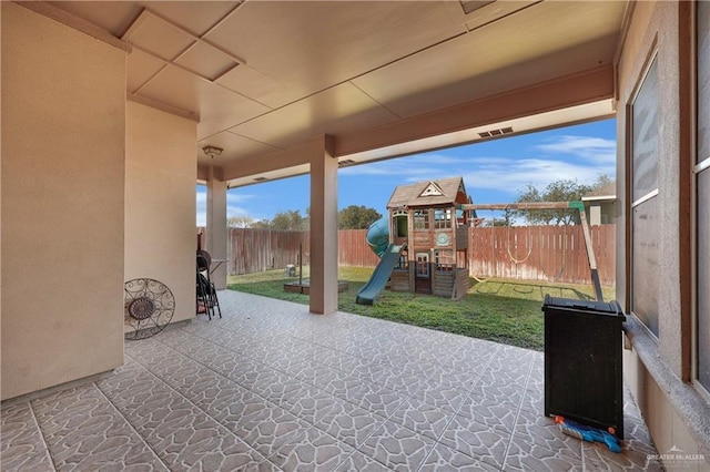 view of patio / terrace featuring a playground and a fenced backyard