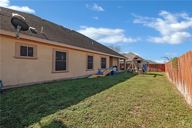 view of yard with a playground and a fenced backyard