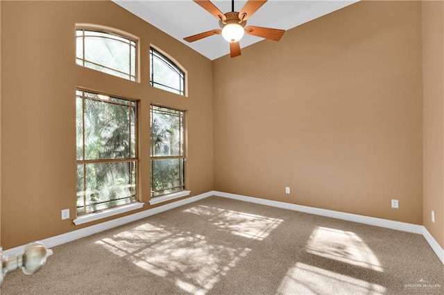 spare room with carpet, ceiling fan, and baseboards