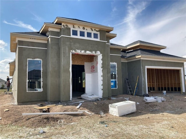 unfinished property with an attached garage and stucco siding