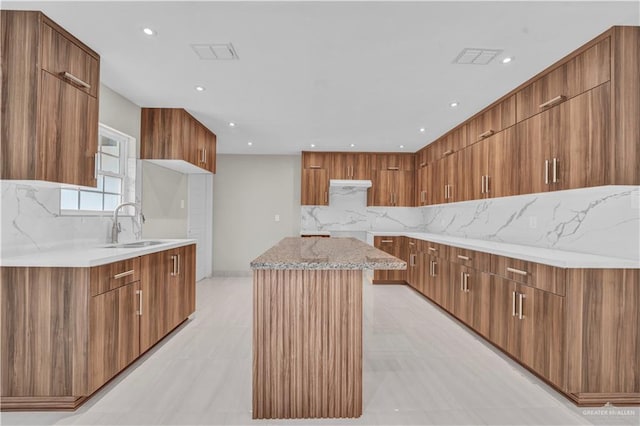 kitchen featuring a large island, modern cabinets, visible vents, and brown cabinetry