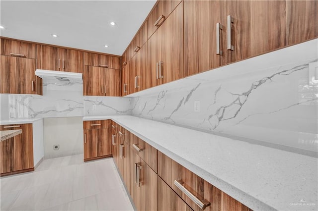 kitchen with light stone countertops, modern cabinets, and brown cabinetry