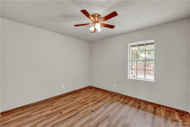 empty room featuring light wood-type flooring, baseboards, and a ceiling fan