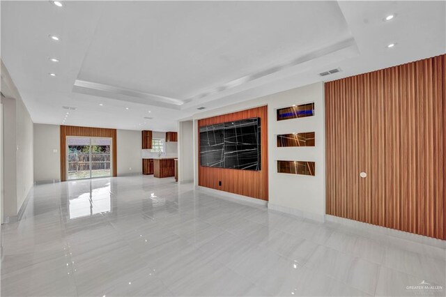 unfurnished living room featuring recessed lighting, a raised ceiling, visible vents, and baseboards