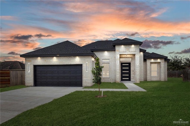 prairie-style home with a garage and a lawn