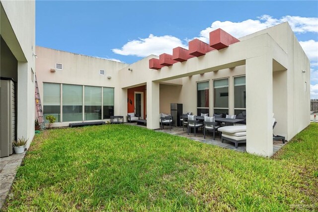 rear view of property featuring a patio area and a lawn