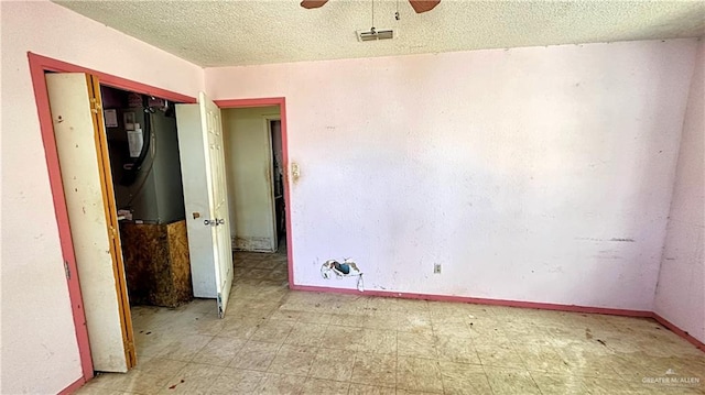 spare room featuring ceiling fan and a textured ceiling