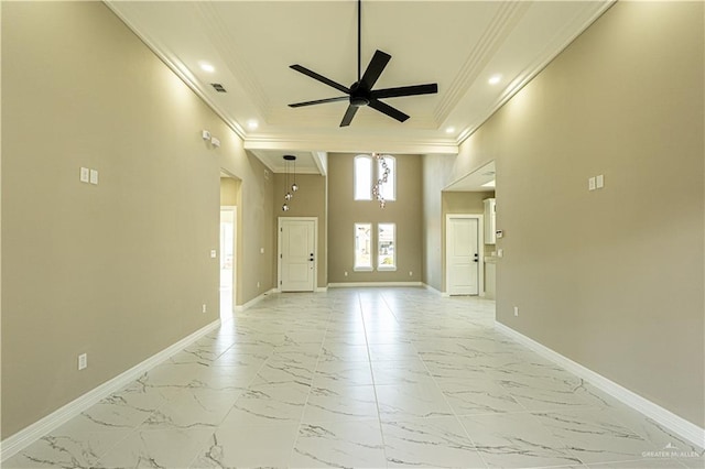 empty room with ornamental molding, marble finish floor, ceiling fan, and baseboards