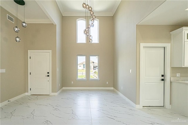 foyer with baseboards, visible vents, marble finish floor, a high ceiling, and crown molding