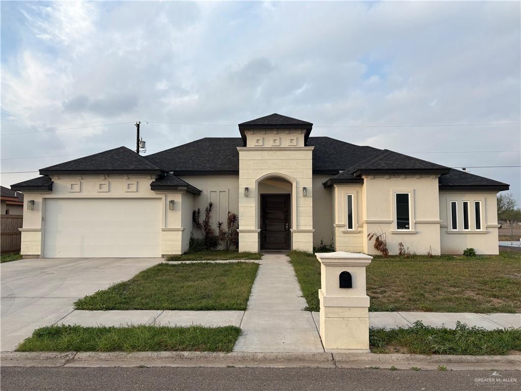 view of front of home featuring a shingled roof, concrete driveway, stucco siding, an attached garage, and a front yard