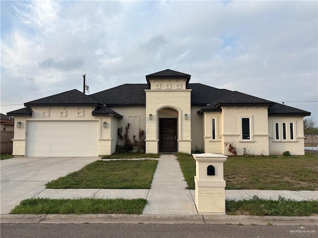 view of front of home featuring a shingled roof, concrete driveway, stucco siding, an attached garage, and a front yard