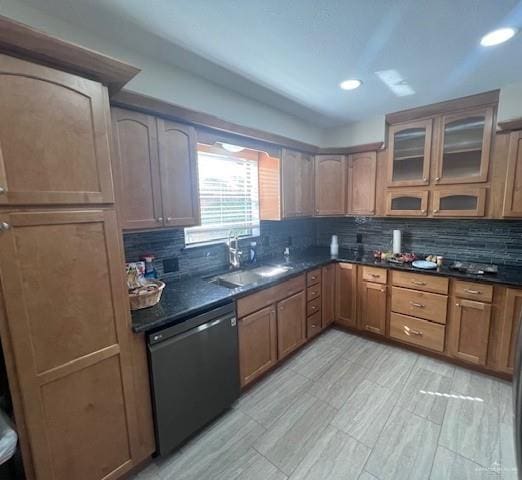 kitchen featuring tasteful backsplash, sink, dark stone counters, and black dishwasher