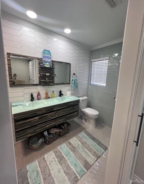 bathroom featuring backsplash, ornamental molding, vanity, hardwood / wood-style flooring, and toilet