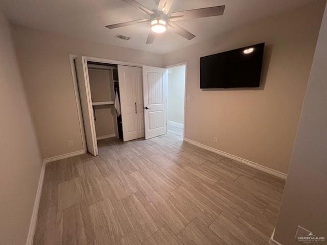 unfurnished bedroom with ceiling fan, a closet, and light wood-type flooring