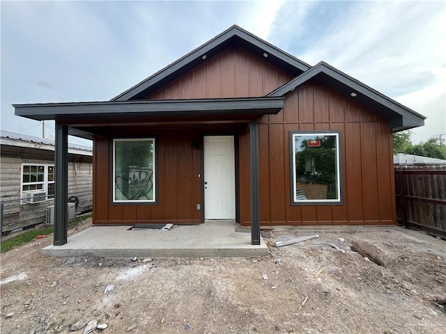 view of front of house with fence and board and batten siding