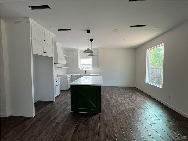 808 E Evans Ave, Pharr, TX 78577 - kitchen featuring custom range hood, dark wood finished floors, a kitchen island, white cabinetry, and decorative light fixtures