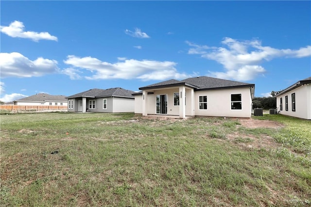 rear view of house with a yard and cooling unit