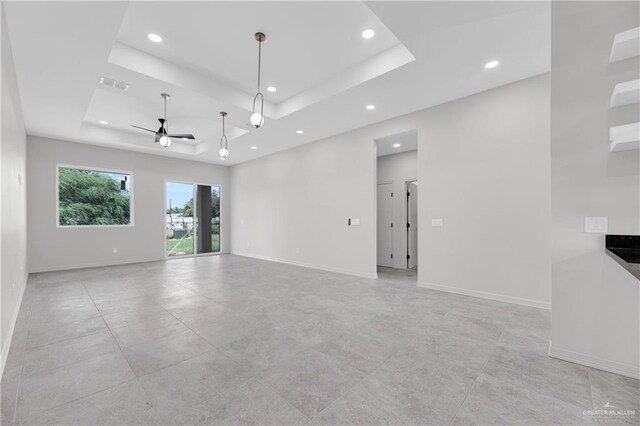 spare room featuring ceiling fan and a tray ceiling