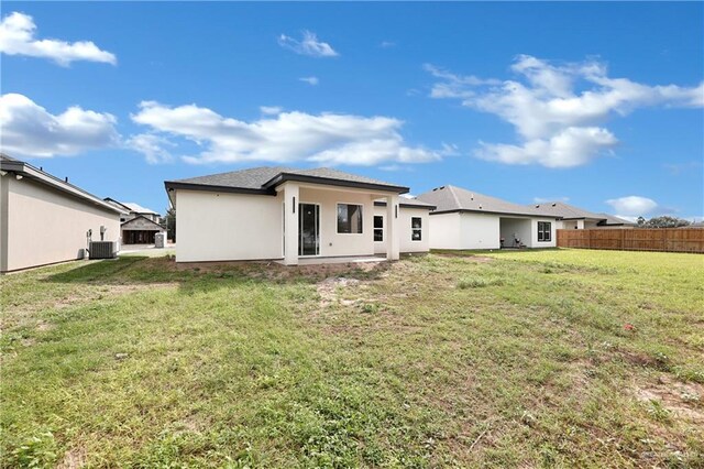 back of property featuring a lawn and cooling unit