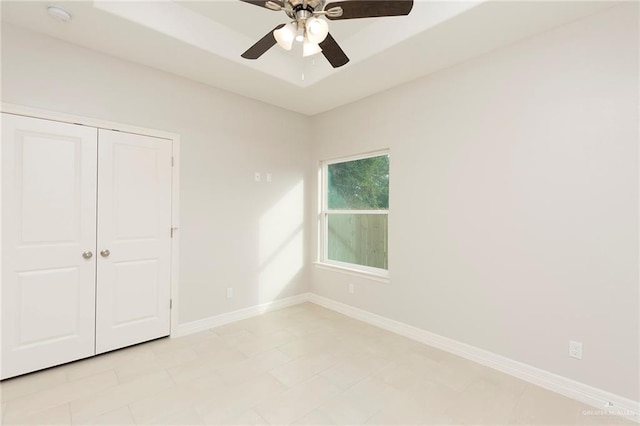 unfurnished bedroom featuring ceiling fan and a closet