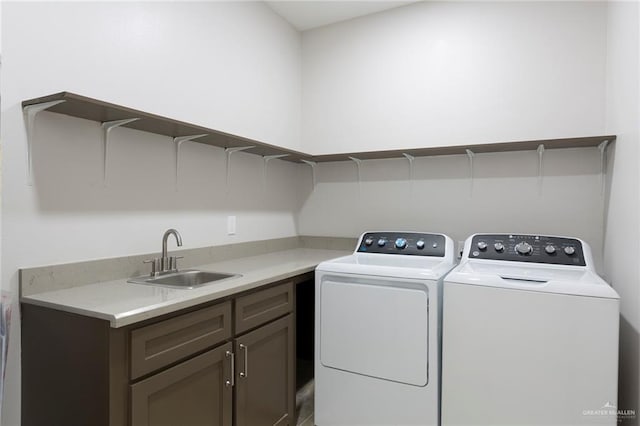 washroom with washing machine and dryer, sink, and cabinets