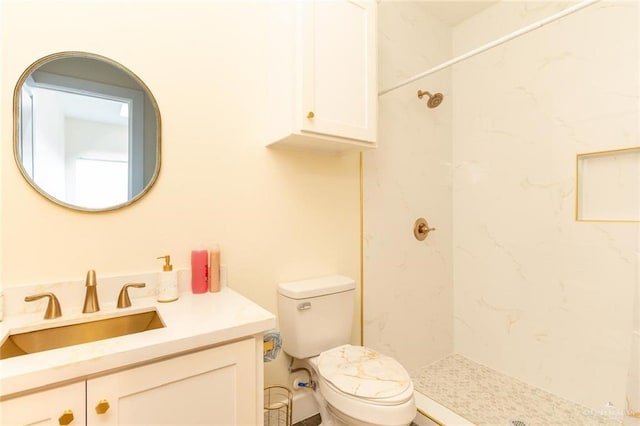 bathroom featuring vanity, toilet, and a tile shower