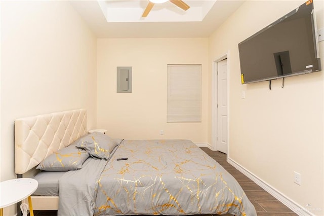 bedroom with dark hardwood / wood-style flooring, electric panel, and ceiling fan