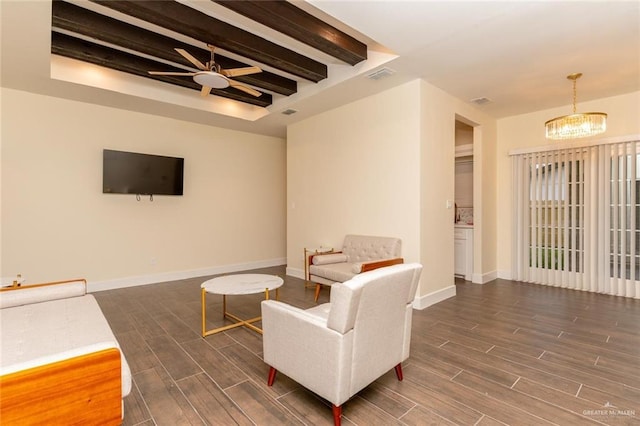 living room with ceiling fan with notable chandelier, dark hardwood / wood-style flooring, and beamed ceiling