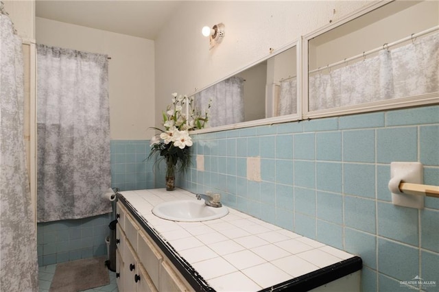 bathroom featuring vanity and tile walls