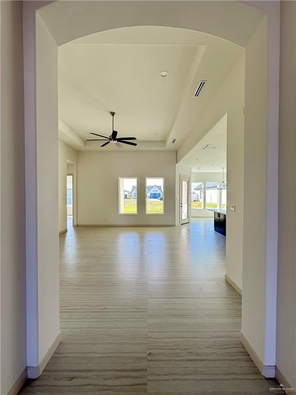 interior space featuring baseboards, light wood-style flooring, visible vents, and a ceiling fan