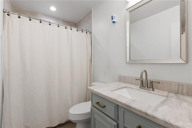 bathroom featuring a shower with shower curtain, vanity, and toilet