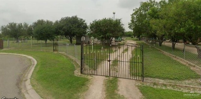 view of gate featuring a yard, a rural view, and fence