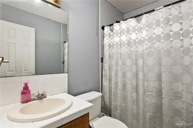 bathroom with curtained shower, tasteful backsplash, a textured ceiling, toilet, and vanity