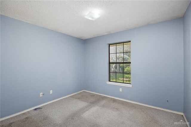 carpeted spare room featuring a textured ceiling