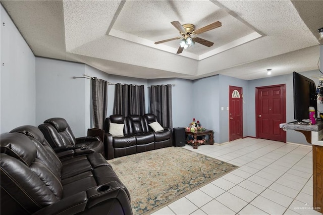 tiled living room with ceiling fan, a raised ceiling, and a textured ceiling