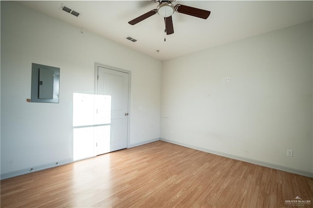 spare room with light wood-type flooring, electric panel, and ceiling fan