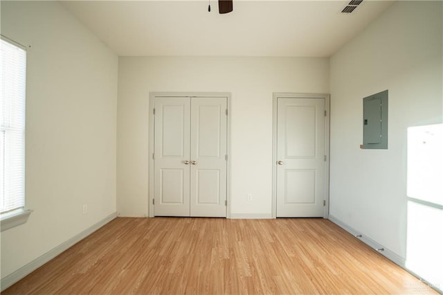 unfurnished bedroom with ceiling fan, light hardwood / wood-style floors, and electric panel