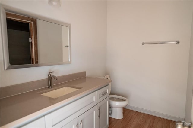 bathroom featuring hardwood / wood-style floors, vanity, and toilet