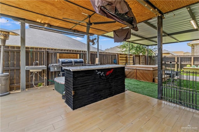 wooden deck featuring sink, a patio, and a hot tub