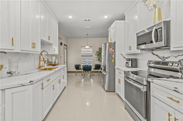 kitchen with white cabinets, hanging light fixtures, light tile patterned floors, and appliances with stainless steel finishes