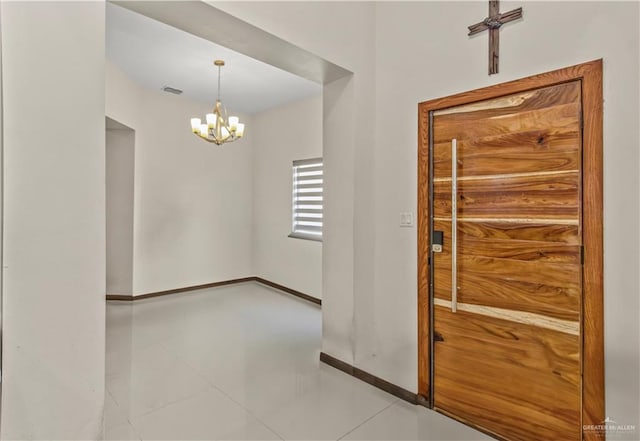 tiled entrance foyer with an inviting chandelier