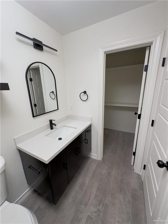 bathroom with hardwood / wood-style floors, toilet, and vanity