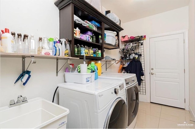 laundry room with washer and dryer, light tile patterned floors, and sink