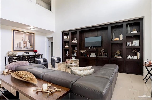 living room featuring light tile patterned floors and a towering ceiling