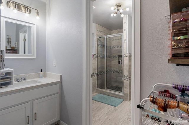 bathroom featuring vanity and a shower with door